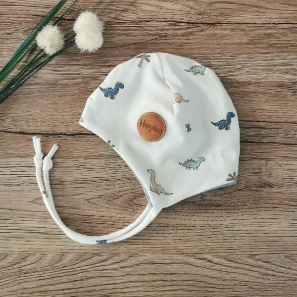 Obojestranska kapica s trakci Baby dino na smetani Hopka Obojestranska kapica s trakci Baby dino na smetani Hopka